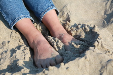 girl sitting on the beach in jeans
