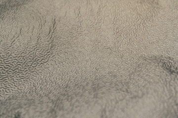 Close-up of abstract texture pattern industrial aluminum foil sheet cap used widely at food industry in partial focus, a common household trash