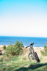 Fototapeta premium Bicycle standing on dunes by the sea shore with view to the Baltic sea