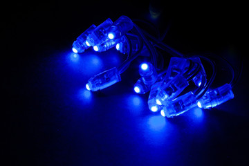 Glowing blue led pixels christmas holiday lights on black background.