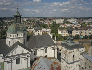 Obraz premium Berdychiv, Ukraine - 7 7 2019: Roman Catholic Church of the Assumption of the Blessed Virgin Mary. Aerial photography of the monastery with defense walls. Baroque architecture in a modern city