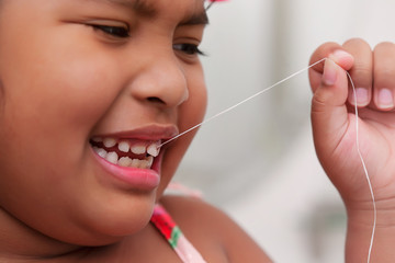 Fear and pain associated with pulling your own baby tooth using a string, as demonstrated by a little girl.