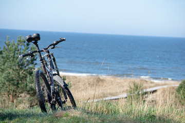 Fototapeta premium Bicycle standing on dunes by the sea shore with view to the Baltic sea
