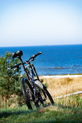 Obraz premium Bike standing on dunes by the sea shore with view to the Baltic sea and sunny day