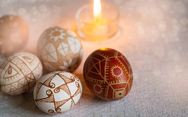 Easter eggs with traditional geometric patterns and a burning candle