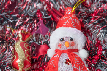 red christmas toy close-up among red ribbons