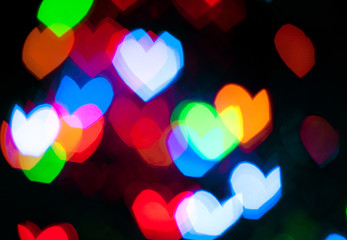 Glowing and festive colored light hearts created from in camera and lens bokeh. Christmas fairy lights defocused giving a blurred effect. Background for design. Valentine's Day