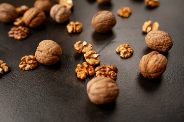 Walnuts. Kernels and whole nuts on a stone background