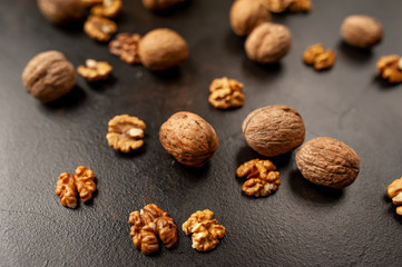 Walnuts. Kernels and whole nuts on a stone background