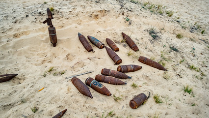Fototapeta na wymiar old rusty artillery shell and aircraft projectile in the desert