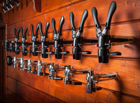 Beer taps for draught drinks are built into wooden boards.