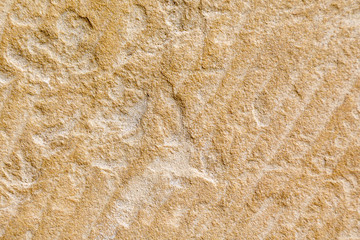 The wall is covered with cement-sand plaster with rough uneven relief