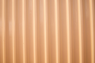 Obraz premium Aluminum fence. Corrugated metal profiled panel. Background of orange metal siding, corrugated iron sheet for decoration