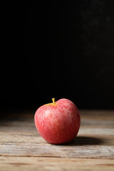 Red apple in vertical with black background