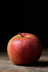 Red apple in vertical with black background