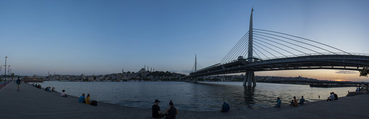 Istanbul, Turkey, Middle East: a breathtaking sunset with panoramic view of the skyline of the city and the Ataturk Bridge, highway bridge on the Golden Horn, seen from the public park along the water