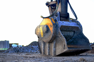 Crushing bucket of the excavator for crushing concrete. Construction waste recycling for construction mix. Sifting and grinding bucket for the separation of concrete into fractions of higher quality.