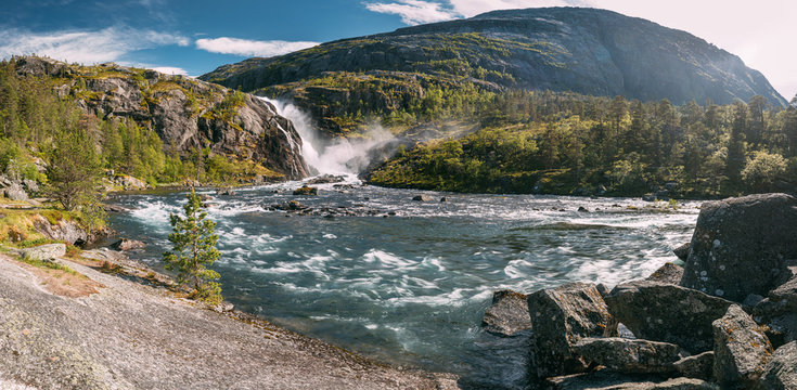 Kinsarvik, Hordaland, Norway. Waterfall Nykkjesoyfossen In Hardangervidda Mountain Plateau. Summer Sunny Day. Height Of 49 M. Famous Landmark And Popular Destination. Panorama, Panoramic View