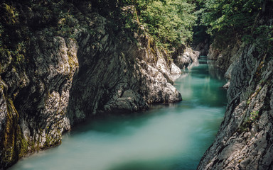 The nature of the Sochi National Park near the Black Sea. Canyon of white cliffs with turquoise water. Tourism in southern Russia. Emerald mountain stream in the Caucasus.