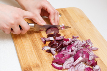 cutting onions on a cutting Board with a knife.