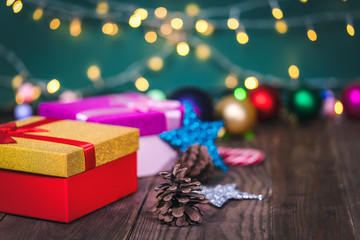 Christmas gift box with christmas balls and cones on a wooden table