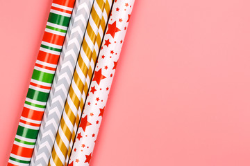Winter creative layot. gift wrapping paper on a pink background. minimalistic christmas scandy...