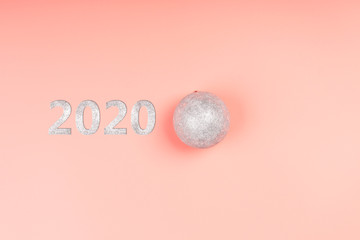 Christmas minimalistic background. Christmas ball on a pink background. silver glitter christmas toy. top view, flat style