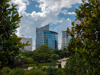 Obraz premium Dwa nowoczesne budynki na tle błękitnego nieba i drzew z przodu.