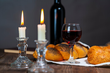Shabbat Shalom. Challah bread, shabbat wine and candles on wooden table.