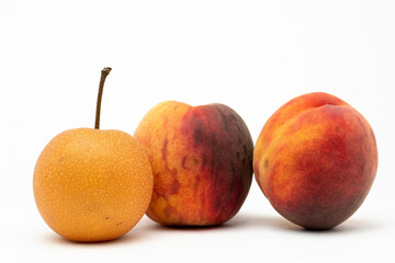 fresh apple and two peaches on the table