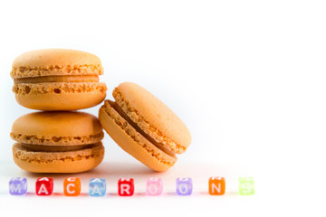 Macaroons with colorful cube letters on white background top, color macaroons, selective focus