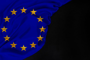 color national European Union flag, symbol of united Europe, beautiful silk, black blank, concept of tourism, economy, politics, emigration, independence day, copy space, template, horizontal