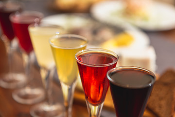 Set of glasses with different colored tinctures made on the basis of fruits and alcohol, a wonderful aperitif before the festive dinner