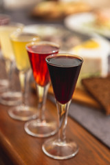 Set of glasses with different colored tinctures made on the basis of fruits and alcohol, a wonderful aperitif before the festive dinner