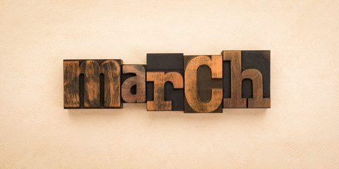 March, word written with vintage letterpress printing blocks on textured background