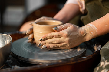 Woman Potter Hands Shaped Mug From Clay. The Process of Creating Pottery On a Potter's Wheel. Working in Ceramics Studio