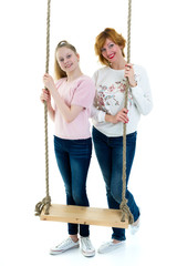 Mom and daughter swinging on a swing.