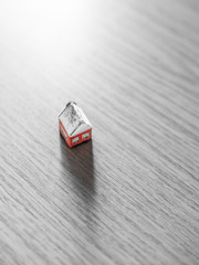 Red house toy on a wooden trable.