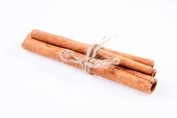 Cinnamon sticks tied with a jute twine on white background
