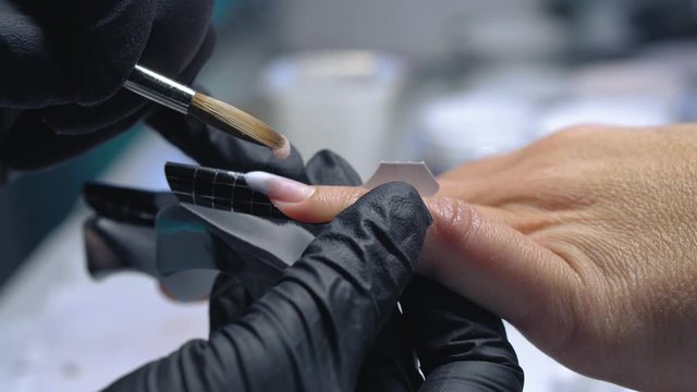 Acrylic Manicure. Master make nail extension. Acrylic nails in a beauty salon. The creation of extension nail salon technician.