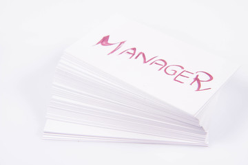 Stack of business cards with 'Manager' handwritten on the top one