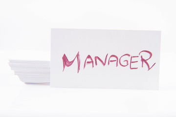 Stack of business cards with 'Manager' handwritten on the top one