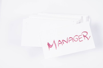 Stack of business cards with 'Manager' handwritten on the top one