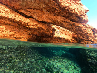 Fototapeta na wymiar Underwater above and below photo of rocky seascape arch forming a beautiful emerald lagoon in tropical exotic island