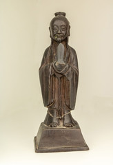 Bonze prêtre bouddhiste de Chine statuette chinoise noire en bronze de face sur fond blanc
