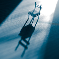 Old chair with a light in the dark blue room.
