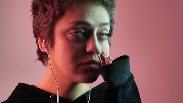 Portrait of a girl who is experiencing stress. Pursed lips and mouth in neon background. Gesture psychology concept 4k