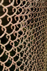 erspective view of a rusty and dirty chained fence in the park - Old braided wire wall used for protection &ndash; Rough textured metallic grid