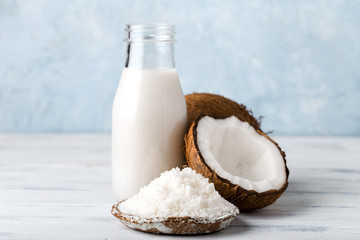 coconut milk in a glass bottle, coconut flour in a plate, light background