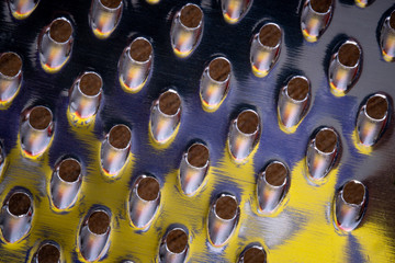 Closeup shot of cheese grater with colorful reflections